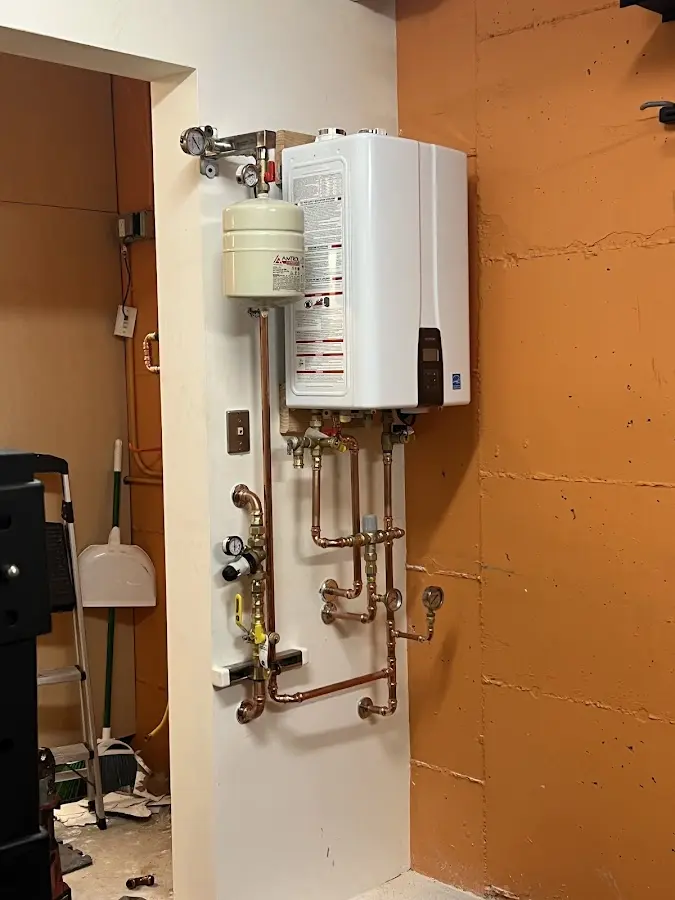 Plumbing technician inspecting water heater connections in Chandler